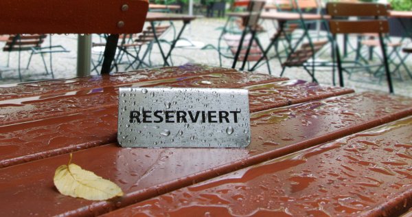 Checkliste Außengastronomie: nasser Tisch mit einem Reserviert-Schild
