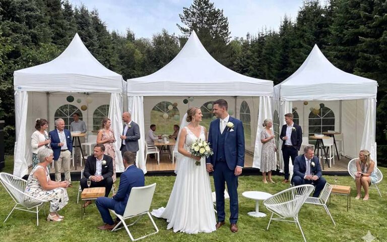 Hochzeit wetterfest planen Ideen: Brautpaar steht vor dei kleinen Hochzeitszelten.